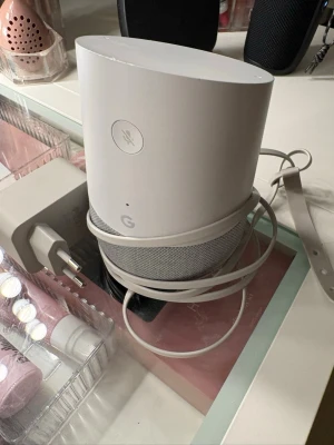 Google Home smart högtalare vit/grå - Super om du inte orkar styra din musik själv på telefon. Snygg och stilren Google Home smart högtalare i vit och ljusgrå färg. Högtalaren har en rundad form med tygklädd nederdel och plast på ovansidan. Perfekt för att styra musik och smarta hemmet med rösten. Strömkabel medföljer. Och även original kartong, original pris 2500kr 