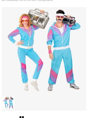 80-tals träningsdräkt blå rosa lila - Säljer en retro 80-tals träningsdräkt i blått, rosa och lila med vita detaljer. Setet består av en zip-jacka och matchande byxor med elastiska muddar. Perfekt för maskerad eller cosplay med klassisk old school stil.
