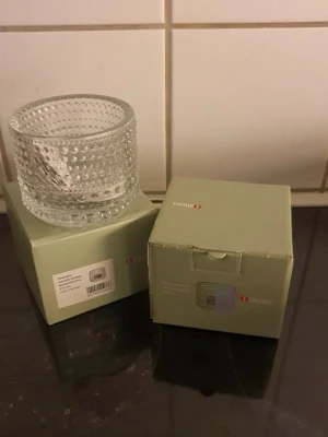 Iittala Kastehelmi ljuslykta klar glas - Säljer en Iittala Kastehelmi ljuslykta i klart glas. Ljuslyktan har ett bubbligt, prickigt mönster som ger ett snyggt ljusspel. Perfekt som dekoration eller för att skapa mysig stämning hemma. 2 stycken 