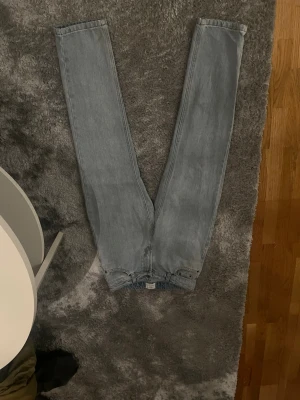 Ljusblå raka jeans - Säljer ett par ljusblå jeans med rak passform och hög midja. Jeansen har klassisk femficksdesign och stora bakfickor. Materialet är kraftig denim i bomull. Perfekta för en avslappnad och trendig look.