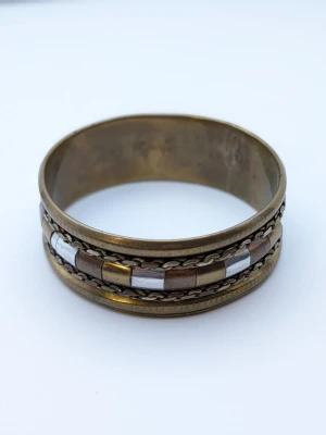 Bredt armband i metall retro 50 tal vintage med kedjedetaljer - Coolt armband i bred modell med mix av guld-, silver- och kopparfärgade metaller. Armbandet har kedjedetaljer och rektangulära länkar som ger en unik och trendig look. Perfekt accessoar för att lyfta din outfit. Patina men går att putsa bort om det inte är ens stilval 