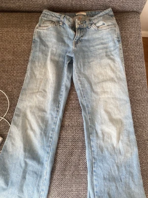 Ljusblå raka jeans från Gina tricot  - Lågmidjade Ljusblå jeans från Gina tricot  med klassisk femficksdesign och raka ben. Jeansen har en snygg tvättad look och är tillverkade i bomull. Perfekta för dig som gillar en avslappnad och stilren vibe.