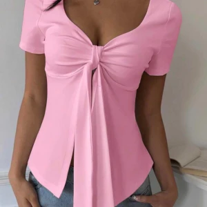Rosa topp med knytdetalj - Passar xs, s och m men skulle säga S bäst. Aldrig använt Snygg rosa topp med korta ärmar och djup v-ringning. Framtill finns en knytdetalj som ger en cool och trendig look. Perfekt att styla med jeans eller kjol för en fräsch outfit.