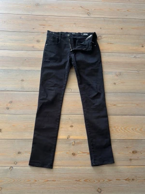 Svarta Replay Anbass jeans - Replay klassiker🇮🇹 - Svarta anbass jeans i strl 31/34. Sitter bra och ger en bra look - perfekt tillskott till garderoben✅Har haft hål som är igen sydda men påverkar inte snyggheten. 🧼 Har några fläckar (se bild) därav priset - endast 299kr!💸 Fri frakt just nu!📦 
