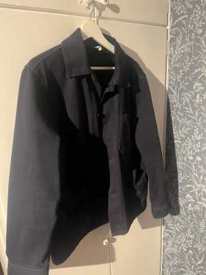 Mörkblå overshirt med fickor - Hej! Säljer denna sköna overshirten från arket i storlek S/M. Har använts fåtal gånger men har mest hängt i garderoben. Hör av dig vid fråga 😊. 