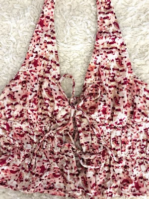 Blommig Halterneck Topp - Söt och somrig topp med blommigt mönster och halterneck-design. Har en lägre/öppen rygg som gör den extra fin ✨ Perfekt till varma dagar och kan enkelt matchas med shorts, jeans eller kjol. Använd få gånger och i fint skick💕Pris kan diskuteras 