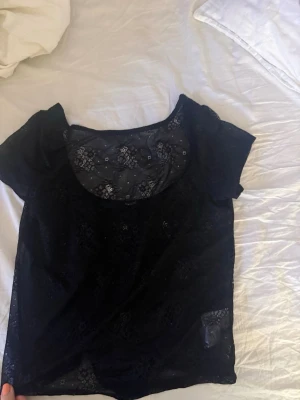 Svart spetsblus från BikBok - Snygg svart t-shirt/blus i spets med öppen rygg från Bikbok i storlek S. Knappt använd snygg till fest! 🥂
