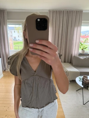 Grå v-ringad blus med knyt i ryggen - Aldrig använd 