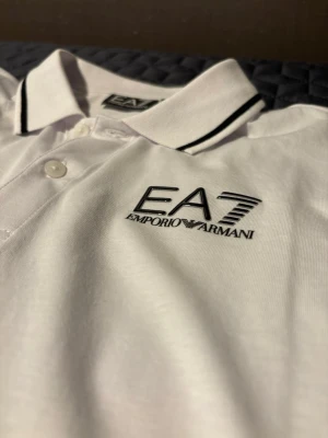EA7 Tröja - Säljer en stilren Armani tröja/skjorta i nyskick. Jag köpte den nyligen men den var tyvärr för stor för mig, därför säljer jag den vidare. Den är aldrig använd.  Ordinarie pris var 2100 kr. Säljes till ett bra pris. Hör av dig vid intresse eller om du har frågor. 