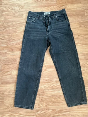 Svarta jeans från Pull&Bear - Snygga svarta jeans från Pull&Bear med klassisk femficksdesign och dragkedja. Jeansen har en rak passform och är tillverkade i bomull. Perfekta för en avslappnad och trendig stil.