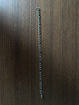 Stainless steel kedjearmband 21 cm - Snyggt armband med klassisk kedjedesign i silverfärg. Armbandet har mellanstora länkar och passar perfekt för en stilren och enkel look. Materialet är metall och armbandet har ett smidigt lås. Perfekt accessoar för att lyfta din outfit.