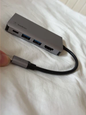 Belkin USB-C hub med HDMI och USB - Hej säljer en Belkin CONNECT USB-C 4-i-1 Multiport-adapter i rymdgrått aluminium.  Den har en HDMI-port som stöder upplösningar upp till 4K.Den inkluderar två USB-A 3.0-portar för anslutning av kringutrustning som möss eller tangentbord.Den har en USB-C-port som stöder upp till 100W genomströmningsladdning (Power Delivery).Adaptern är designad för bärbara datorer och surfplattor, och mäter ungefär 90 x 45 x 13 mm.  MYCKET BRA SKICK, använd fåtal gånger  Postar endast helger 💛 frågor? Tveka inte!