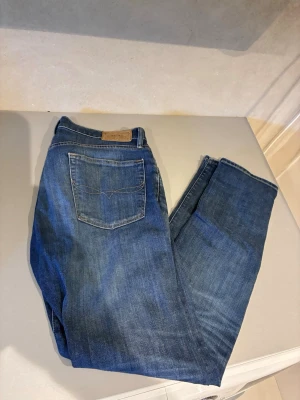 Blå jeans från Polo Ralph Lauren - Snygga blå jeans från Polo Ralph Lauren med klassisk femficksdesign och raka ben. Jeansen har en mörk tvätt och detaljerade sömmar på bakfickorna. Tillverkade i bomullsdenim för en skön och avslappnad känsla.