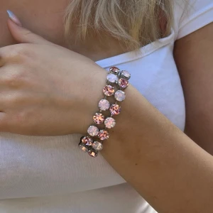 Armband kristaller i två rader - Armband med blandade kristaller Aurora, Preciosa, Swarowski, egen design. Silverpläterad mässing. Två rader med kristaller. Light Rose och Light Rose De Lite ss39, 8mm stora kristaller. Längd 24cm inkl lås och förlängningskedja.   Jag skickar endast spårbart, samfraktar. Fast pris. Besök gärna mina övriga annonser.
