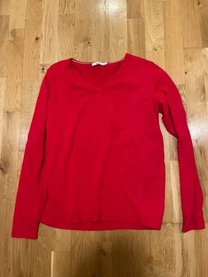 Röd V-ringad tröja från Cecil stl S  - Snygg röd långärmad tröja från Cecil med V-ringning. Enkel och stilren design som passar perfekt till jeans eller kjol. Tillverkad i mjukt material för en bekväm känsla hela dagen.