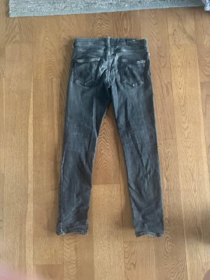 Replay jeans  slim fit - Säljer ett par grå slim fit jeans från replay och är söndriga vid skrevet och bak fickan men är lagade. Är storlek 14 år 