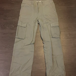  Khakigröna cargobyxor från Pull&bear - Khakigröna cargobyxor i jeanstyg från Pull&bear. Storlek 42, använda fåtal gånger!