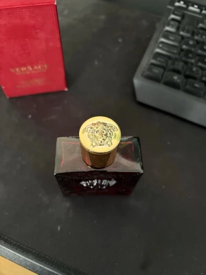 Versace Eros Flame parfym 50ml - Versace Eros Flame parfym i en lyxig röd glasflaska med guldigt lock prytt med Medusa-huvudet. Flaskan har ett elegant mönster och kommer med originalförpackning i matchande rött. En ikonisk doft från Versace som sticker ut både i design och känsla. Har 45 ml kvar!!!