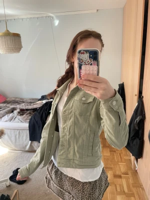 Ljusgrön jeansjacka med fickor - Snygg ljusgrön jeansjacka med klassisk krage och knappstängning framtill. Jackan har två bröstfickor med lock och knappar samt två sidofickor. Perfekt att slänga över en t-shirt för en avslappnad look. Hör av dig för frågor❣️