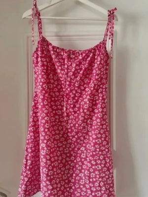 Klänning  - Säljer en blommig kort klänning som endast är använd en gång. Storlek L men jag skulle säga att den passar en storlek M.