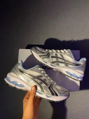 Asics Gel Kayano 14 - Helt nya silveriga Asics gel Kayano 14. Storlek 43. Skriv ifall intresserad, priset är inte hugget i sten. 