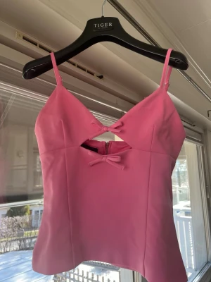 Rosa linnetopp med rosetter - Trendig rosa topp från Zara. Storlek xs aldrig använd. Söt rosett och dragkedja i ryggen.