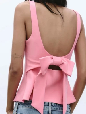 Rosa linnetopp med stor rosett från Zara!!💕 - Supersöt rosa linnetopp med fyrkantig urringning och breda axelband. Toppen har en öppen rygg och en stor rosett bak som ger en extra gullig touch. Perfekt att styla med jeans eller kjol för en trendig look. Har alldrig använt den och den är i storlek xs från Zara!!❤️