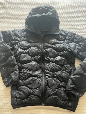 Svart dunjacka Peak Performance - Snygg svart dunjacka från Peak Performance i storlek small. Ganska tunn, perfekt nu till våren 💕 Finns ett hål i vardera arm, men går att sy ihop om man kan och vill det. Funkar till både tjej och kille 
