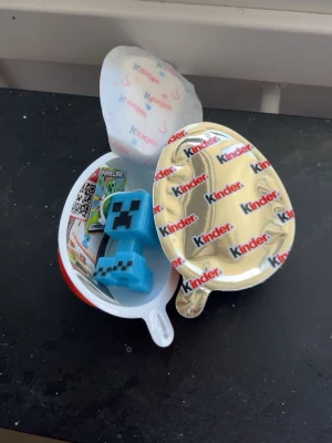 Minecraft Charged Creeper samlarfigur - Blå Charged Creeper samlarfigur från Minecraft, med pixel-design och svart ansikte. Figuren är tillverkad i plast och kommer med en tag med Minecraft-logga och texten 'Charged Creeper'. Perfekt för fans av spelet och som dekoration eller nyckelring. Medföljer choklad och helt stängd.