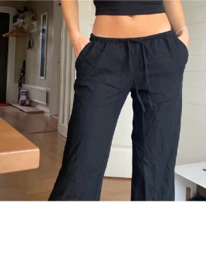 Svarta linnebyxor med dragsko - Snygga svarta linnebyxor från hm med avslappnad passform och dragsko i midjan. Byxorna har raka ben och sidfickor. 🥰