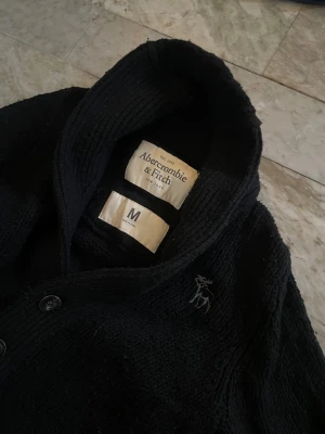 Abercrombie and Fitch cardigan - Riktigt snygg och skön Abercrombie and Fitch kofta i st M! Bra skick! Hör av dig vid ytterligare frågor! Mvh Hugo