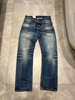 Selvedge Nudie Jeans Loose Leif - Säljer dessa sjukt snygga helt nya nudie selvedge jeansen. Dom är i modellen loose Leif och sitter straight. De är i storleken 29/30 men sitter större. Skriv vid minsta fråga/fundering👌Midja: 39 cm, Längd: 105 cm, Benöppning: 20 cm