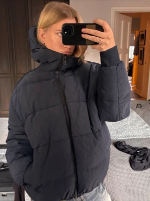 Zadig och Voltaire dun/pufferjacka med huva   - Säljer den perfekta marin blå dunjacka/pufferjacka med hög krage och stor huva från Zadig och Voltaire. Köpt från deras butik. Jackan har dragkedja framtill, två sidofickor och breda muddar vid ärmsluten. Perfekt för kalla dagar och riktigt mysig att bära. Passar till jeans och andra vardagsplagg.