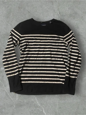 Randig långärmad tröja från Scotch & Soda | L - Snygg långärmad tröja från Scotch & Soda med svarta och vita horisontella ränder. Tröjan har rund halsringning och är tillverkad i mjukt bomullsmaterial. Perfekt för en avslappnad och trendig stil.