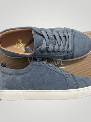 Christian Louboutin - Snygga blå sneakers i mocka från Christian Louboutin med klassisk låg profil och vita sulor. Skorna har matchande blå skosnören och diskreta sömdetaljer. Perfekta för dig som vill ha en clean och exklusiv look.