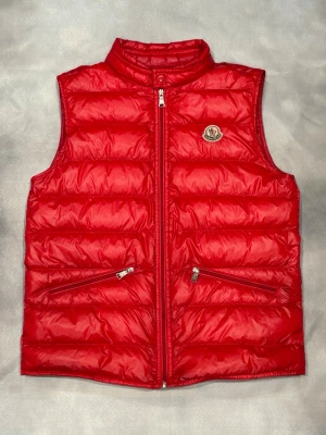 Röd Moncler gui väst  - Röd moncler gui väst | Storlek - 14 years - Passar XS | Skick - 8/10 | Bra skick | Äkta | Hör av er vid frågor eller funderingar 🙌
