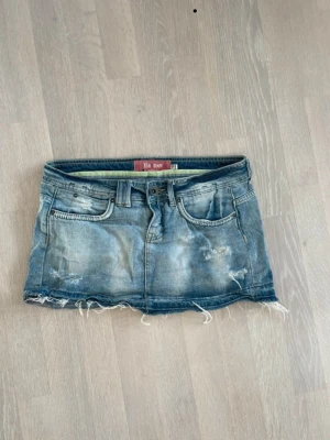 Blå jeanskjol med slitna detaljer - Snygg jeanskjol från bershka. Jätte bra skick och knappt använd. Slitna detaljer som får kjolen att se mer vintage ut. 