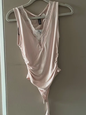 Ljusrosa spetsbody från H&M - Supersnygg ljusrosa body från H&M med prislapp kvar. Säljer då den inte kommer till användning. Den är perfekt för fest eller fin middag🌸💓💓 ny pris 179kr