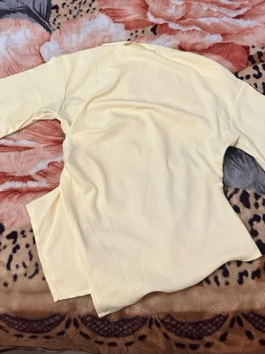 Ljusgul långärmad topp - En stilren ljusgul långärmad topp med enkel design och mjukt material. Perfekt att matcha med jeans eller kjol för en fräsch look. Toppen har rund halsringning och är figurnära utan att vara för tight. Helt oanvänd