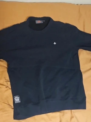 Marinblå sweatshirt från Morris - Stilren marinblå sweatshirt från Morris. Tröjan har rund halsringning, diskret logga på bröstet och en patch vid nederkanten. Perfekt för en avslappnad och trendig look.