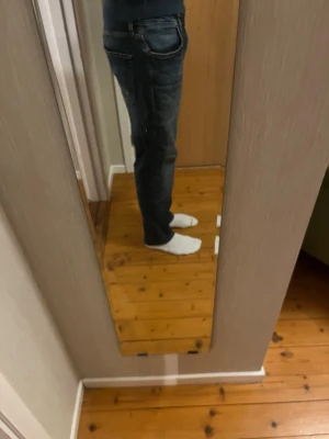 Mörkblå raka jeans från Jack and Jones  - Säljer ett par mörkblå jeans med raka ben och klassisk femficksdesign. Jeansen har diskreta slitningar och kontrastsömmar för en snygg look. Perfekta till vardags och passar till det mesta. Materialet är denim i bomull.