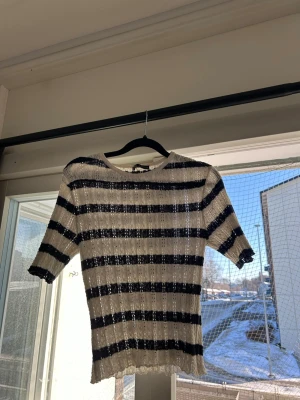 Randig topp med kort ärm - Säljer en vit, marinblå randig topp. Aldrig använd. Obs liten i storlek!!!!