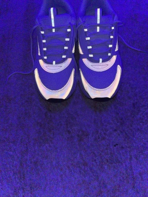 Nike sneakers med reflexdetaljer - Säljer ett par Dior sneakers med coola reflexdetaljer som lyser upp i mörkret. Skorna har en sportig design med mesh och syntetmaterial, samt klassisk Dior-logga på tungan. Perfekta för dig som vill sticka ut med din stil. Dom är för stora det är därför jag säljer dessa.