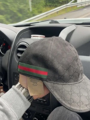 Svart Gucci keps med GG-mönster - Säljer en svart keps från Gucci med klassiskt GG-mönster över hela kepsen. På sidan finns en grön och röd rand som ger den där lyxiga känslan. Tillverkad i Italien och har en böjd skärm. Perfekt för dig som vill ha något stilrent och exklusivt.