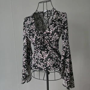 Superfin och unik blus med utsvängda ärmar - En riktigt fin och lite speciell blus med vackert utsvängda ärmar som ger en elegant och feminin look. Den är figurnära men stretchig, vilket gör att den sitter snyggt och framhäver midjan på ett väldigt smickrande sätt ✨ Endast använd två gånger – i nyskick. Passar både XS och S. Perfekt både till vardag och fest 💫 Säljes då den tyvärr inte kommer till användning.