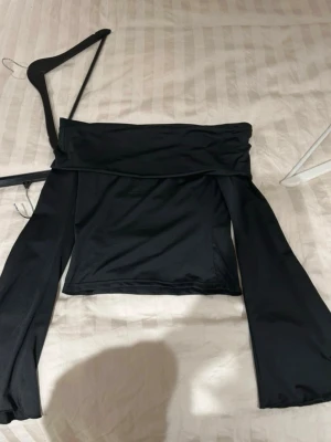 Svart offshoulder topp - Svart offshoulder topp med långa, vida ärmar och croppad passform. Aldrig använd 