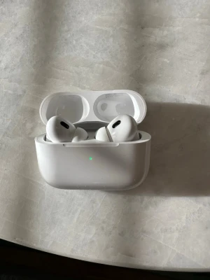 AirPods Pro (2:a generationen) - AirPods Pro (2:a generationen). Fick dem i julklapp men använder mina tidigare hörlurar istället.  Endast använda ett fåtal gånger och i mycket fint skick. Fungerar som de ska. Återställda och noggrant rengjorda inför försäljning. Redo att skickas.  Säljs med laddetui och tillbehör enligt bilder.  Aktiv brusreducering (ANC) och USB-C-laddning.  Pris kan diskuteras vid smidig affär. Skick enligt bilder. 