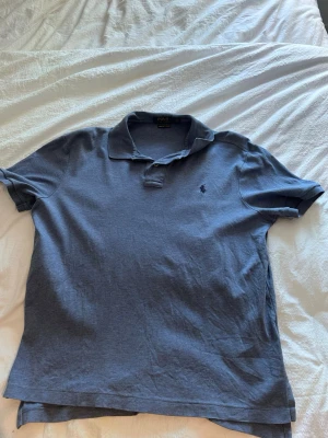 Blå pikétröja från Polo Ralph Lauren - Klassisk blå pikétröja från Polo Ralph. Storlek L. Mjukt material.