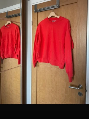 Röd sweatshirt från Weekday - En enkel och snygg röd sweatshirt från Weekday i storlek XS. Tröjan har rund halsringning, långa ärmar och ribbade muddar vid ärmslut och nederkant. Tillverkad i mjukt bomullsmaterial som är skönt att ha på sig.