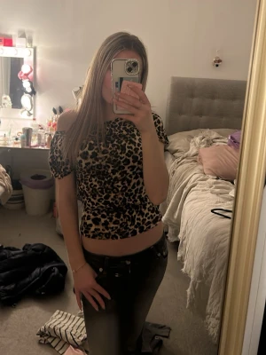Leopardmönstrad offshoulder topp - Snygg croppad topp med leopardmönster och offshoulder-design. Toppen har korta ärmar och sitter tight mot kroppen. Perfekt för dig som vill sticka ut med en trendig och djärv look.